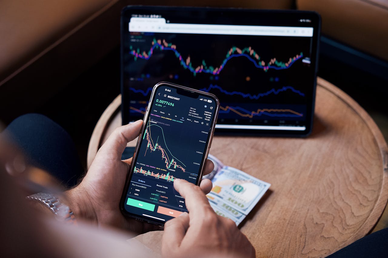 Man Looking at the Stock Charts on the Phone and Tablet 